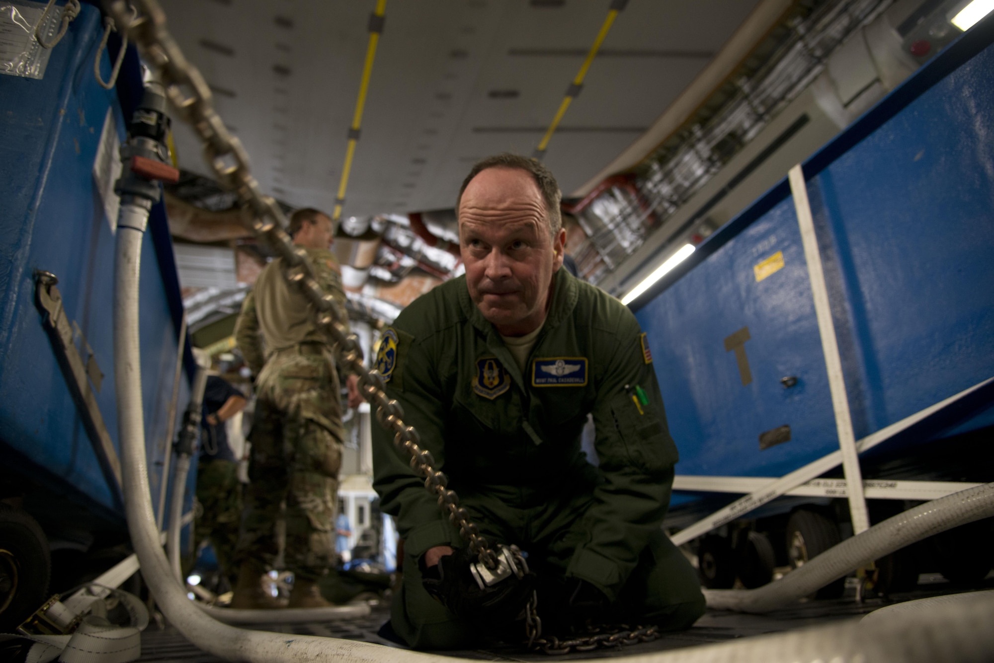 Master Sgt. Paul Casadeval, 301st Airlift Squadron, chains down a government vehicle during a mission from Naval Air Station Key West, Fla., to San Diego April 28, 2017. The 301st AS transported four Bottlenose Dolphins and their handlers to the U.S. Naval Marine Mammal Program where they train to assist the U.S. Navy with locating mines and enemy swimmers. (U.S. Air Force photo/Staff Sgt. Nicole Leidholm)