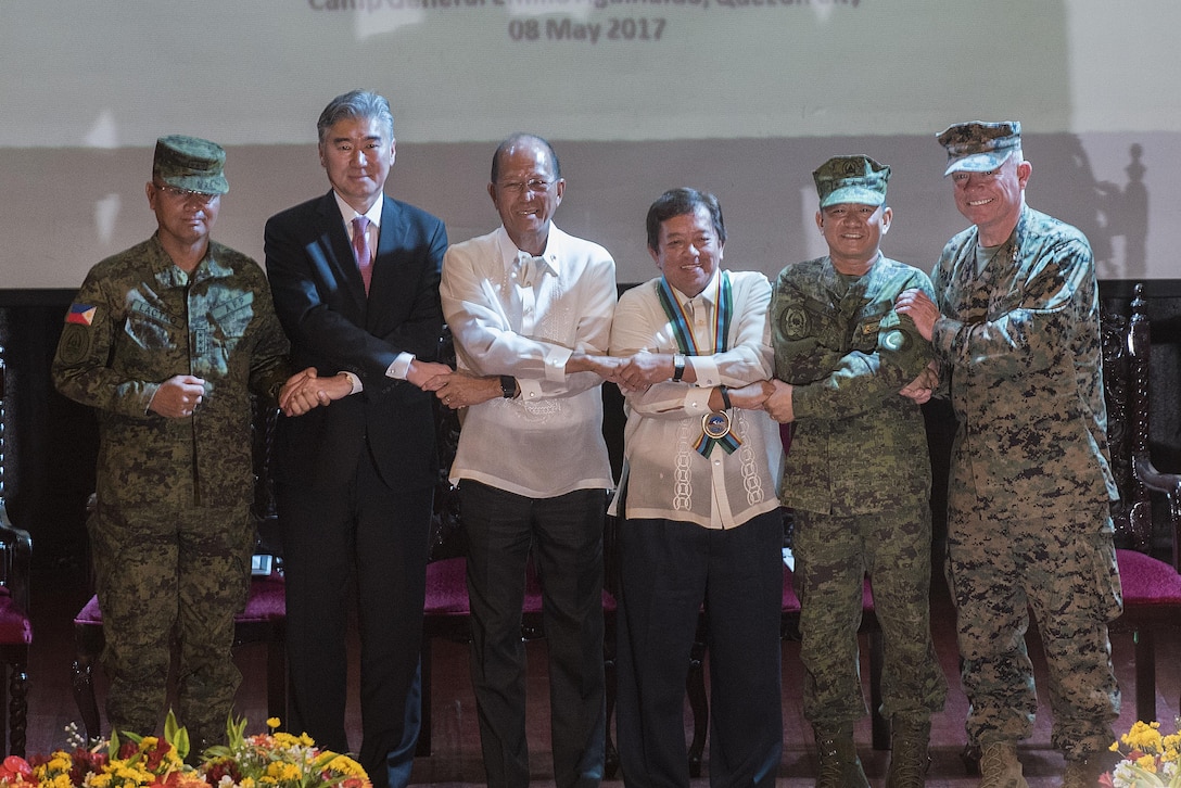 Armed Forces of the Philippines Lt. Gen. Oscar T. Lacto, left, The Honorable Ambassador Sung Y. Kim, Secretary Delfin N. Lorenzana, Under Secretary Ariel y. Abadilla, AFP Gen. Edruardo M. Año, and U.S. Marine Lt. Gen. Lawrence D. Nicholson stand “shoulder-to-shoulder” and shake hands during the opening ceremony for Balikatan 2017 at Camp Aguinaldo, Quezon City, May 8, 2017. Lacto is the Philippine exercise director for Balikatan. Kim is the U.S. Ambassador to the Philippines. Lorenzana is the Philippine Secretary of National Defense. Abadilla is the Philippine Undersecretary for Civilian Security and Consular Concerns. Año is the Chief of Staff of the AFP. Nicholson is the commanding general of III Marine Expeditionary Force. Balikatan is an annual U.S.-Philippine bilateral military exercise focused on a variety of missions including humanitarian and disaster relief, counterterrorism, and other combined military operations. 