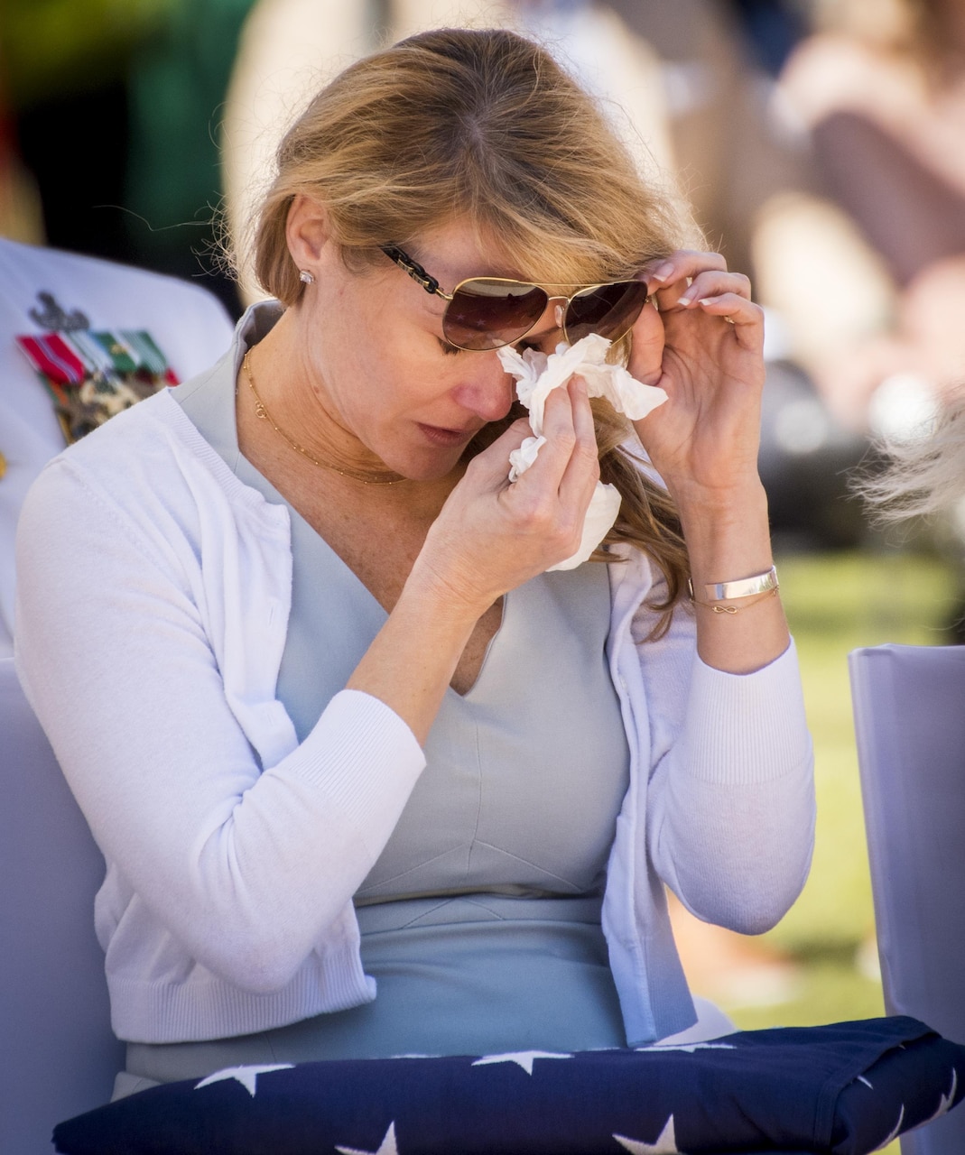 Kristen Dayton, widow of Senior Chief Petty Officer Scott Dayton, wipes away a tear after receiving a folded flag during the 48th Annual Explosive Ordnance Disposal Memorial Service, May 6. Dayton and other names of recent fallen and past EOD technicians are added to the memorial wall and flags presented to their families during a ceremony each year at the Kauffman EOD Training Complex at Eglin Air Force Base, Fla. The Army and Navy added six new names this year. The all-service total now stands at 326. (U.S. Air Force photo/ Samuel King Jr.)