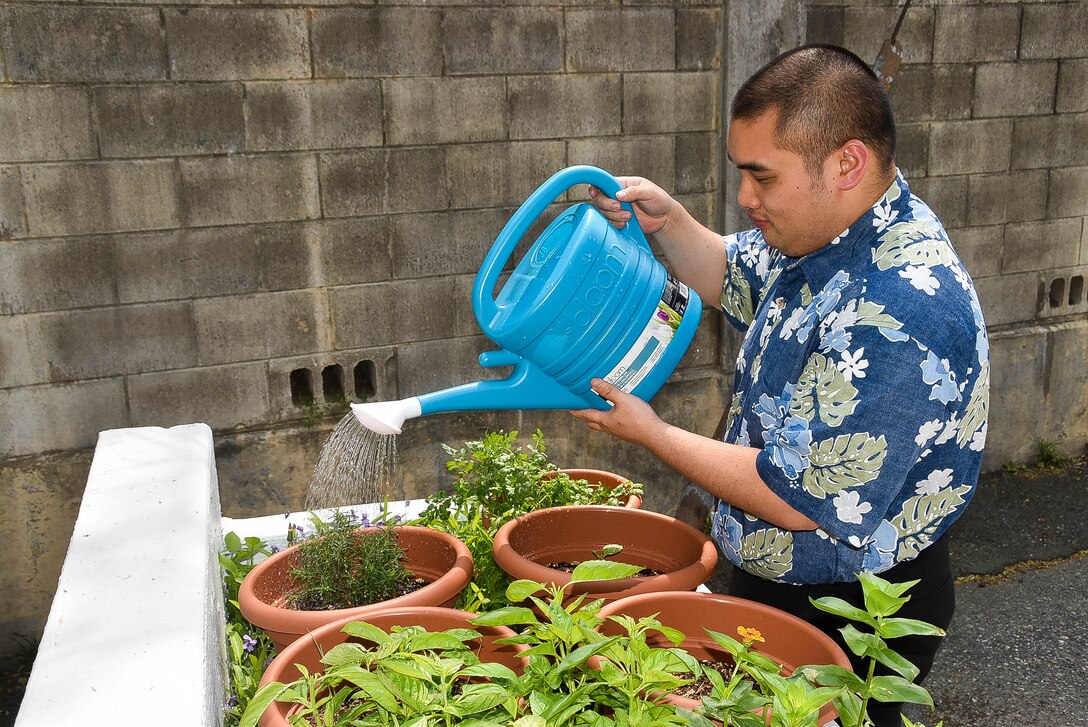 Philip Siu waters his herb garden at the Far East District compound, April 29.