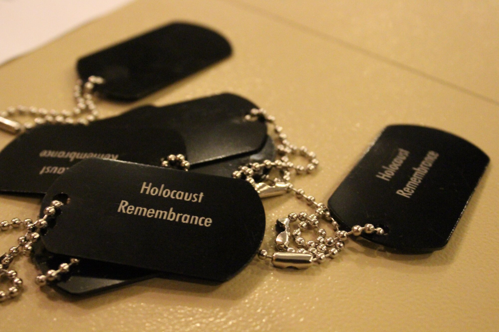 Commemorative dog tags sit on a table during a Holocaust Remembrance event April 27, 2017 in Southwest Asia.  The event featured a remembrance walk and a museum that educated over 100 people. (U.S. Air Force Photo by Tech Sgt. Eboni Reams)