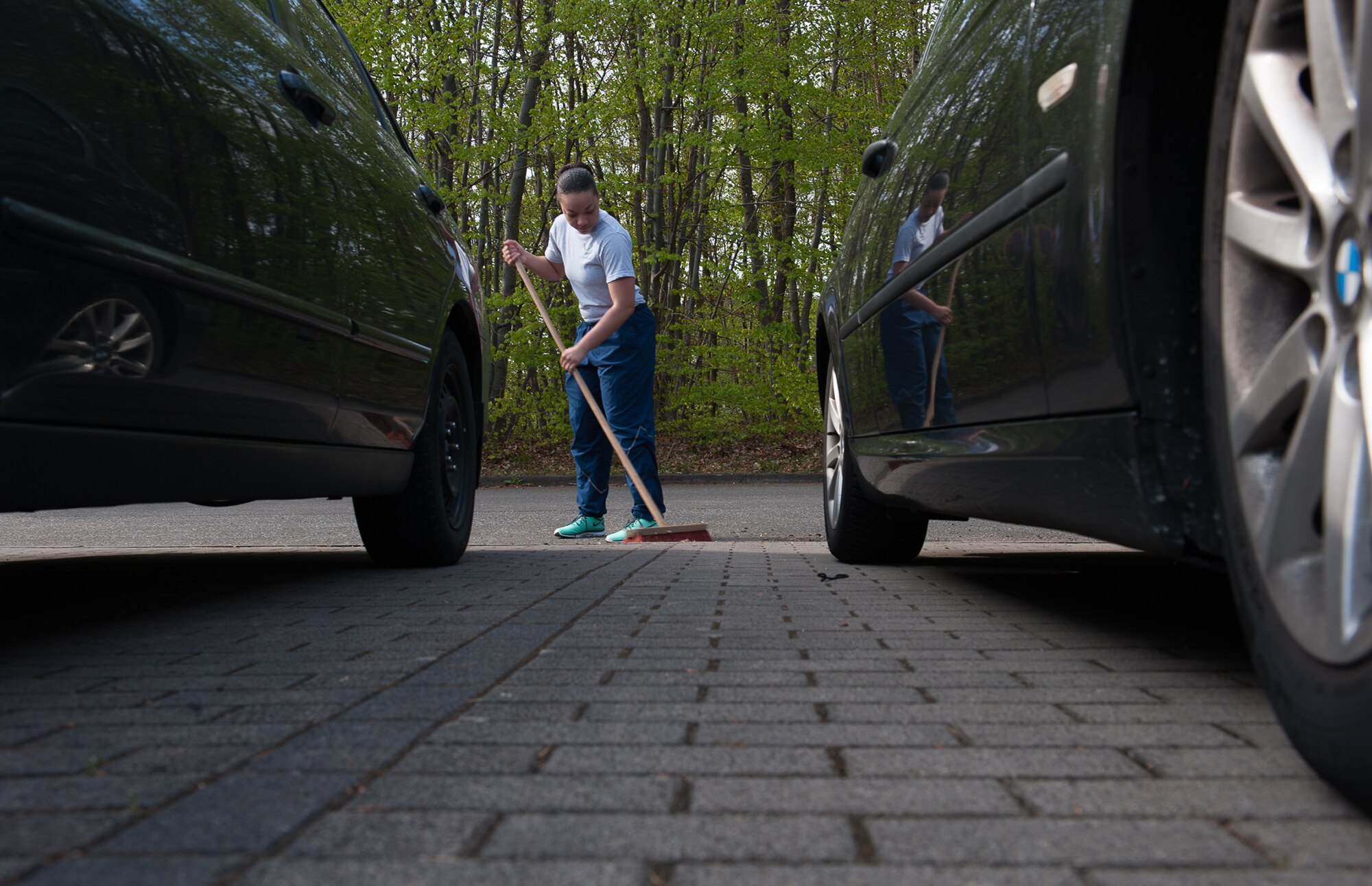 Airman 1st Class Monique Stokes, 721st Aerial Port Squadron passenger service specialist, sweeps during a 'Clean Where You Live' event at Ramstein Air Base, Germany, May 3, 2017. Clean Where You Live is a day designated for the cleaning of common areas around military family housing and dormitories. (U.S. Air Force photo by Airman 1st Class Savannah L. Waters)

