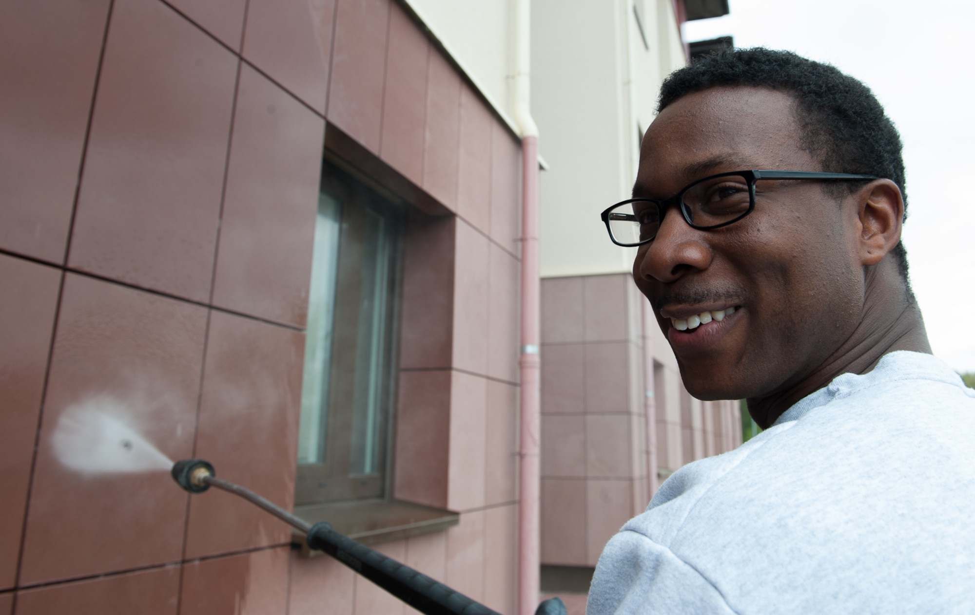 Airman 1st Class Jaron Augustus, 86th Communications Squadron client systems technician, uses a pressure washer to clean the exterior of a building at Ramstein Air Base, Germany, May 3, 2017. The 86th Airlift Wing, in coordination with U.S. Army Garrison Kaiserslautern, organized spring cleanup events to help maintain clean living and work areas. (U.S. Air Force photo by Airman 1st Class Savannah L. Waters)