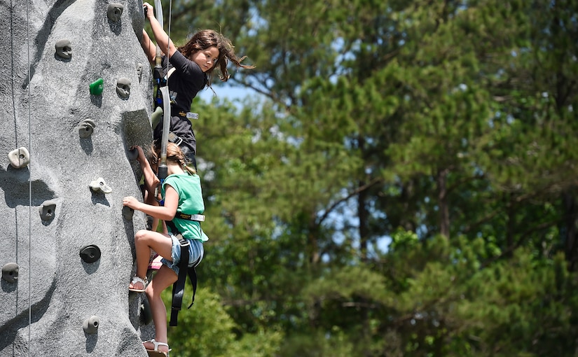 Sofia, 10 years old, top, Eliza, 7 years old, bottom, both daughters of U.S. Air Force Capt. Ricardo Sequeira, 628th Medical Group and 14th Airlift Squadron flight surgeon, climb a rock wall during a base picnic at the Air Base Picnic Grounds May 5, 2017, at Joint Base Charleston, S.C. Attendees were provided free meals and were able to participate in various activities including face painting, wall rock climbing, live music and a Military Working Dog demonstration.