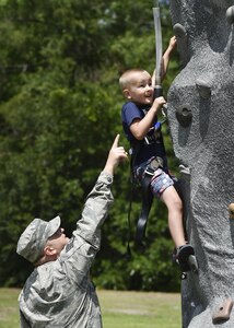 Staff Sgt. Adam Perry, 628th Air Base Wing Safety Office occupational safety specialist, watches his son Wesley, 4 years old, climb a rock wall during a base picnic at the Air Base Picnic Grounds May 5, 2017, at Joint Base Charleston, S.C. Attendees were provided free meals and were able to participate in various activities including face painting, wall rock climbing, live music and a Military Working Dog demonstration.