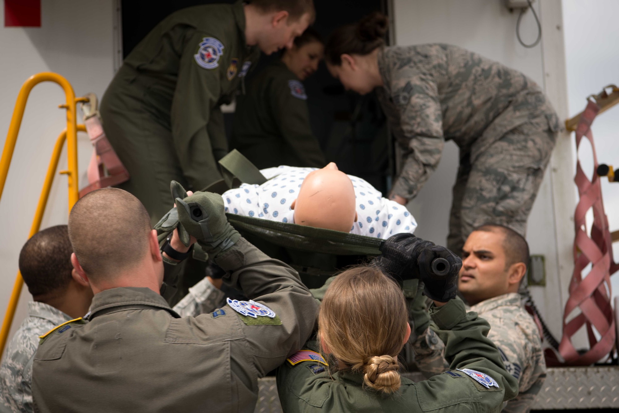 Members of the 86th Aeromedical Evacuation Squadron lift a mannequin onto a high deck patient loading platform during a patient movement exercise on Ramstein Air Base, May 4, 2017. Practicing patient evacuation in a realistic setting helps all involved personnel learn how to respond to unexpected complications that might occur in real-world scenarios.  (U.S. Air Force photo by Senior Airman Elizabeth Baker/Released)