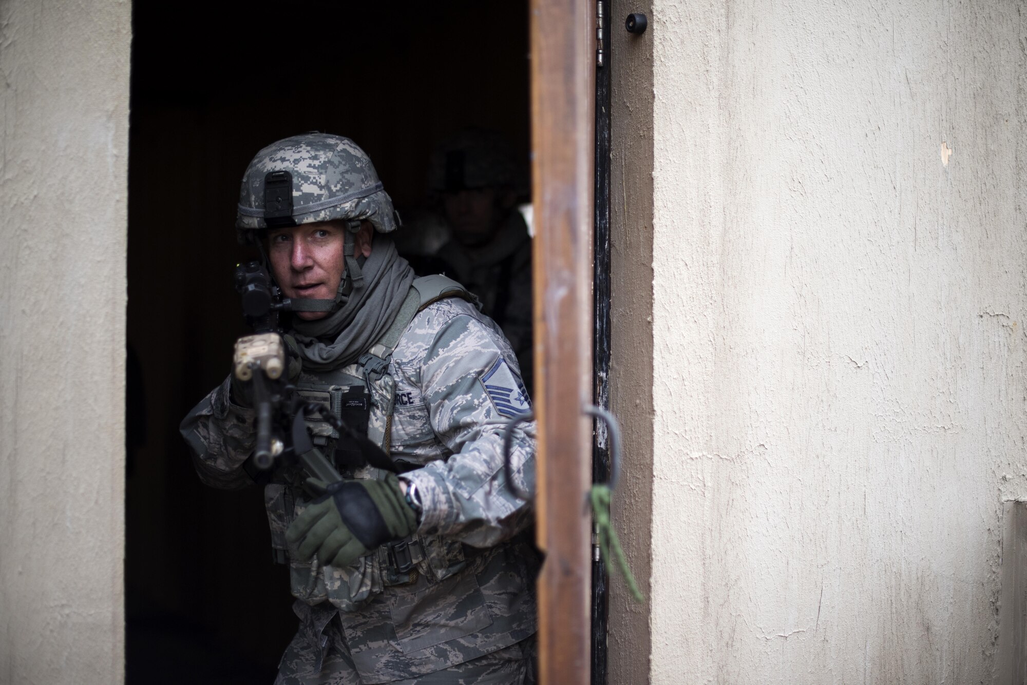 A 48th Security Forces Squadron member breaches a door during a training exercise at the Stanford Training Area, England, April 21. 48th SFS Airmen practiced clearing an entire section of a village built specifically for training purposes. (U.S. Air Force photo/Senior Airman Malcolm Mayfield)