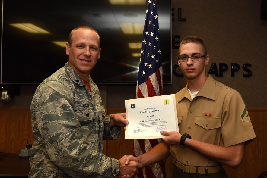 U.S. Air Force Lt. Col. Steven Watts, 17th Training Group deputy commander, presents the 316th Training Squadron Student of the Month award for April 2017 to Lance Cpl. Marshall Briggs, 316th TRS student, in Brandenburg Hall on Goodfellow Air Force Base, Texas, May 5, 2017. (U.S. Air Force photo by Airman 1st Class Caelynn Ferguson/Released)