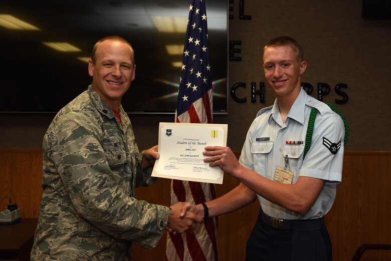 U.S. Air Force Lt. Col. Steven Watts, 17th Training Group deputy commander, presents the 315th Training Squadron Student of the Month award for April 2017 to Airman 1st Class Job Elliot, 316th TRS student, in Brandenburg Hall on Goodfellow Air Force Base, Texas, May 5, 2017. (U.S. Air Force photo by Airman 1st Class Caelynn Ferguson/Released)
