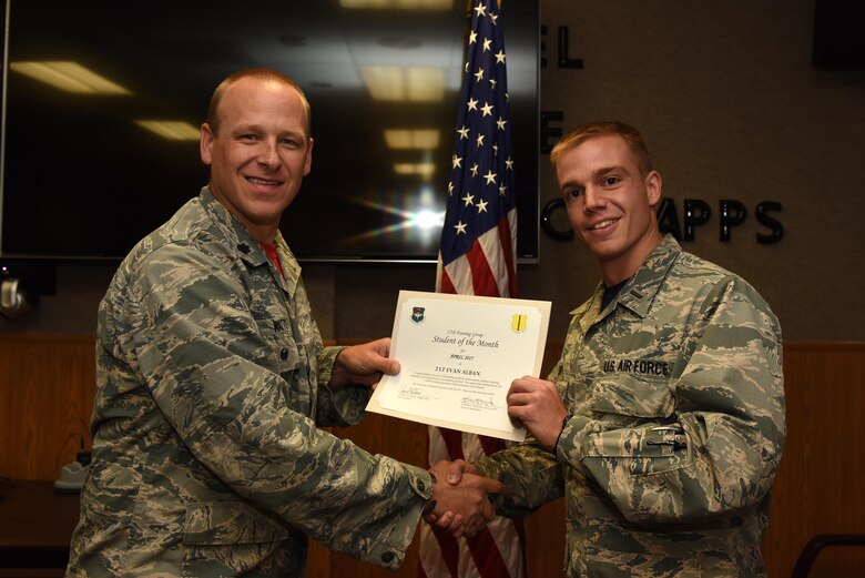 U.S. Air Force Lt. Col. Steven Watts, 17th Training Group deputy commander, presents the 315th Training Squadron Officer Student of the Month award for April 2017 to 2nd Lt. Evan Alban, 315th TRS student, in Brandenburg Hall on Goodfellow Air Force Base, Texas, May 5, 2017. (U.S. Air Force photo by Airman 1st Class Caelynn Ferguson/Released)