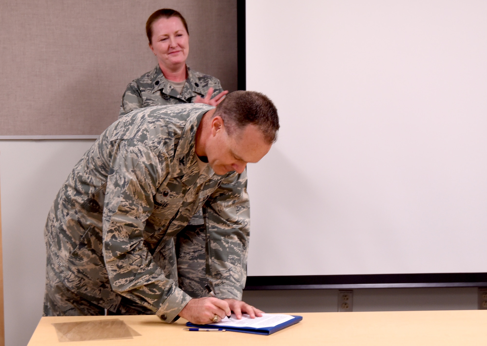 Col. Jeffery White, 377th Medical Group commander, signs a proclamation for National Nurses and Medical Technicians Week at a ceremony at the Health Clinic May 8. The ceremony honored the group's nurses and technicians for their contributions to world-class healthcare. 