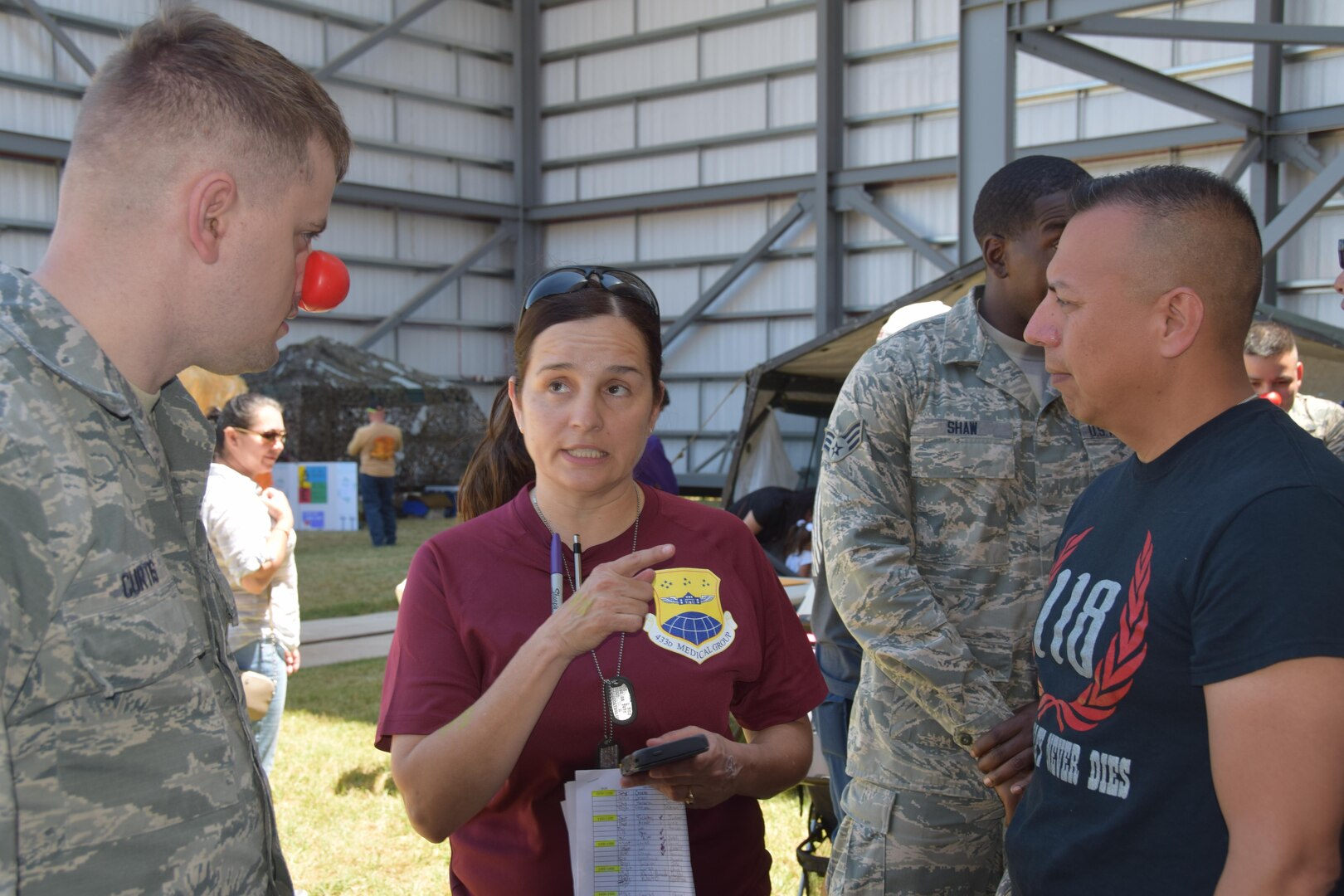 Master Sgt. Brian Curtis (left), a 433rd Aeromedical Staging Squadron medical technician, and Chief Master Sgt. Ernesto Flores, a 433rd Medical Group Health Services Manager, listen to Chief Master Sgt. Lisa Steffes, 433rd Aerospace Medicine Squadron superintendent of nursing services, concerning the various medical stations  at the 433rd Airlift Wing’s Family Day May 7, 2017 at Joint Base San Antonio-Lackland, Texas. The stations were manned by 433rd MDG Airmen who presented lessons on hand cleaning, CPR, dental hygiene and substance abuse. (U.S. Air Force photo by Tech. Sgt. Carlos J. Trevino) 