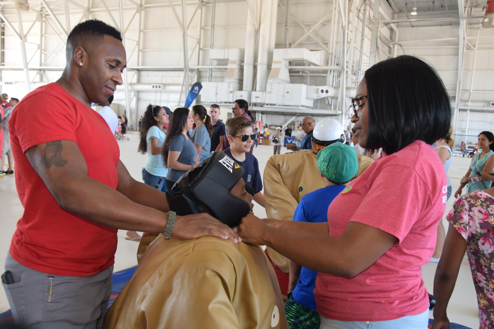 Staff Sgt. Tiffany Collins (right), a 433rd Aeromedical Evacuation Squadron medical technician, and her spouse, Doug, suit-up their son, Doug Jr. in a sumo suit at the 433rd Airlift Wing’s Family Day May 7, 2017 at Joint Base San Antonio-Lackland, Texas.  There were many activities for children including four bounce castles, a medical skills area and a dance off. (U.S. Air Force photo by Tech. Sgt. Carlos J. Trevino)