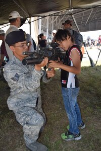 Staff Sgt. Pedro Rodriguez, 433rd Security Forces Squadron, explains how a M-4 rifle and grenade launcher operates to Daniel Mifsud during the 433rd Airlift Wing Family Day May 7, 2017 at Joint Base San Antonio-Lackland, Texas.   (U.S. Air Force photo by Tech. Sgt. Carlos J. Trevino)