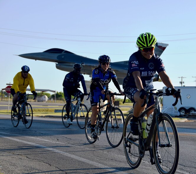Cyclists pass a 149th Fighter Wing F-16 static display during the 433rd Airlift Wing’s Family Day May 7, 2017 at Joint Base San Antonio-Lackland, Texas. Cyclists of all levels rode the course and got an official Air Force Cycling shirt for participating. (U.S. Air Force photo by Tech. Sgt. Carlos J. Trevino) 
