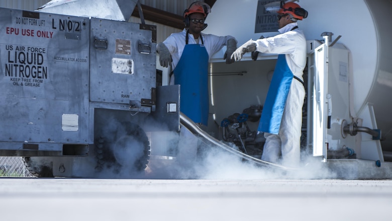 Senior Airman Daniel Striggles, a 49th Logistics Readiness Squadron fuels facilities operator, and Senior Airman Christopher Benavente, a 49th LRS fuel cryogenics operator, fill a cart with liquid nitrogen at Holloman Air Force Base, N.M. on May 5, 2017. Cryogenics operations involve servicing liquid nitrogen and liquid oxygen to Holloman’s aircraft. The liquid oxygen is pure, almost 99 to 100 percent oxygen, which Holloman’s F-16 pilots breathe during flight, and liquid nitrogen is used for tire services to aircraft. (U.S. Air Force photo by Airman 1st Class Alexis P. Docherty) 