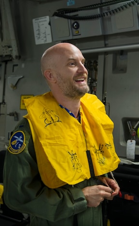 Leon Logothetis, TV personality and author of The Kindness Diaries, laughs while trying on a flotation device during a pre-flight safety briefing at Joint Base Charleston, S.C, May 5, 2017. Logothetis came to JB Charleston to deliver his message of being kind and doing right by others. Logothetis also flew with the 14th Airlift Squadron to receive a firsthand look at the mission of the 437th Airlift Wing and Air Mobility Command.