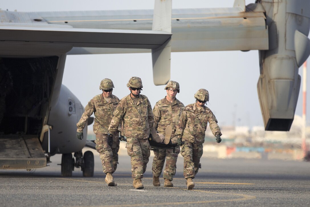 U.S. Army combat medics, with the 86th Combat Support Hospital, move a simulated casualty off of a MV-22 Osprey, during a joint training exercise with Marines from Marine Medium Tiltrotor Squadron - 364 (VMM-364), at Camp Arifjan, Kuwait May 8, 2017. (U.S. Army Photo by Sgt. Christopher Bigelow)