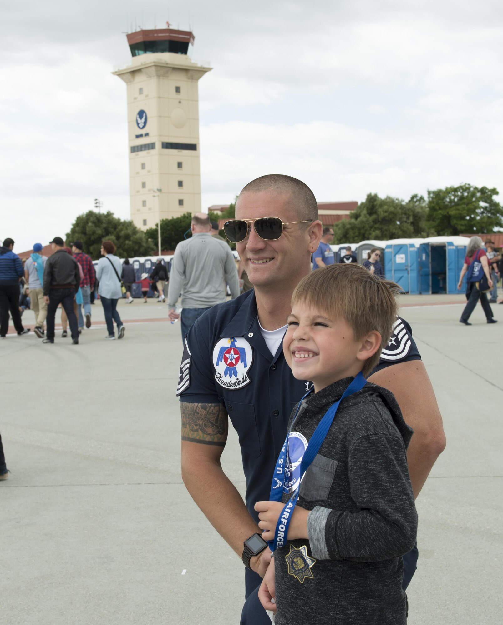 A member of the U.S. Air Force Thunderbirds poses for a photo with a child at the Wings Over Solano Air Show at Travis Air Force Base, Calif., May 6, 2017. The two-day event featured performances by the Thunderbirds, U.S. Army Golden Knights parachute team, flyovers and static displays. (U.S. Air Force photo by Heide Couch)