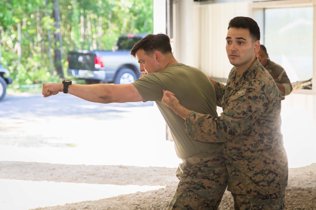 Marine Corps Sgt. Brian A. Bean, left, and Sgt. Reese B. Casillas demonstrate a lead hand punch to students attending the Marine Advisor Course at Marine Corps Base Camp Lejeune, North Carolina, May 4, 2017. The Marines conducted the final rehearsal exercise of the course to assess students' readiness to train foreign security forces during their upcoming deployment to Central America. Bean and Casillas are tactics instructors with the Ground Combat Element, Special Purpose Marine Air-Ground Task Force - Southern Command. The Marine Advisor Course is taught by the Marine Corps Security Cooperation Group. Marine Corps photo by Sgt. Ian Leones