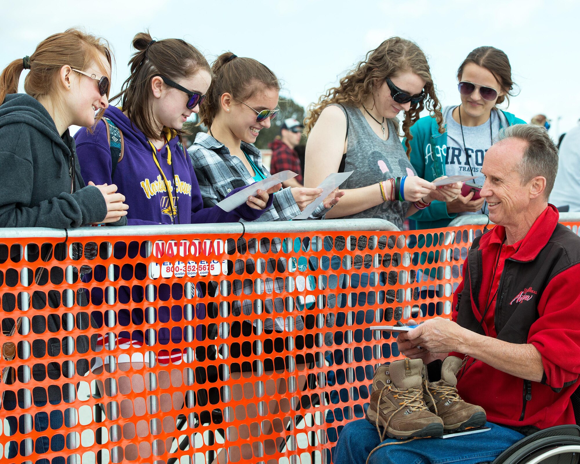 Hang glider Dan Buchanan, a performer in the Wings Over Solano Air Show at Travis Air Force Base, Calif., signs autographs for fans May 6, 2017. Buchanan lost the ability to walk during an accident years ago but, despite his handicap, still loves performing in front of thousands of people. (U.S. Air Force photo by Louis Briscese)