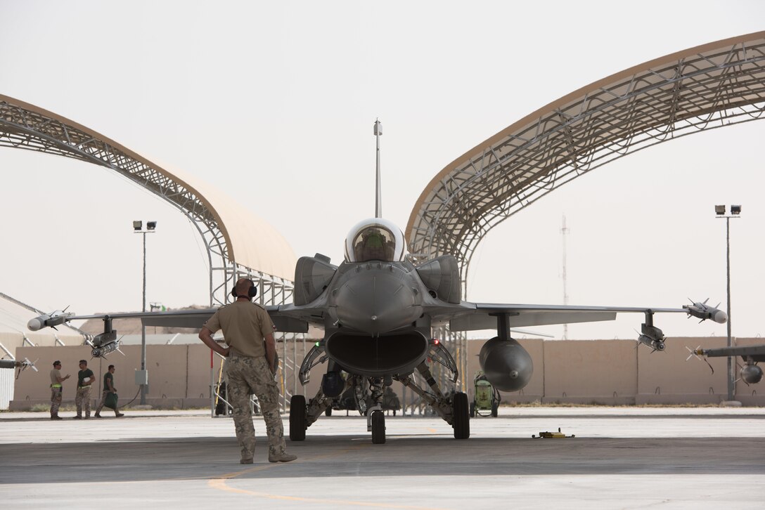 A Polish air force maintainer looks on as an F-16 Fighting Falcon prepares to taxi for a mission at the 407th Air Expeditionary Group, April 24, 2017. The Polish Airmen are part of the 60-nation coalition force supporting Operation Inherent Resolve in the fight against ISIS.  (U.S. Air Force photo/Master Sgt. Benjamin Wilson)(Released)(U.S. Air Force photo/Master Sgt. Benjamin Wilson)(Released)
