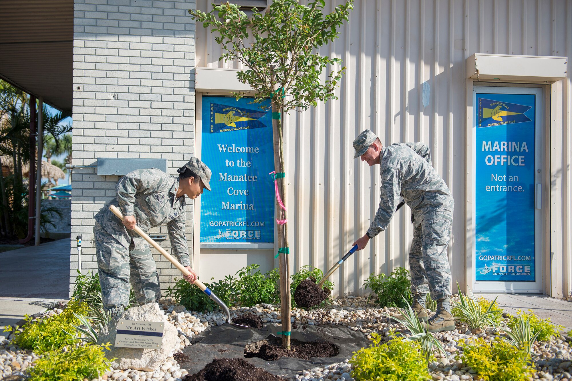 Maj. Chong Gregory, 45th Force Support Squadron commander, and Brig. Gen. Wayne Monteith, 45th Space Wing commander, participate in a tree planting ceremony to honor the memory of the late retired Senior Master Sgt. Arthur Fetskos and his many years of service, April 21, 2017, at the Manatee Cove Marina as part of Earth Day activities at Patrick Air Force Base, Fla. The 45th Space Wing celebrated Earth Day with multiple activities to include a Beach Cleanup at Cape Canaveral Air Force Station and also setup an educational display at the Base Exchange. (U.S. Air Force photo by Matthew Jurgens) 