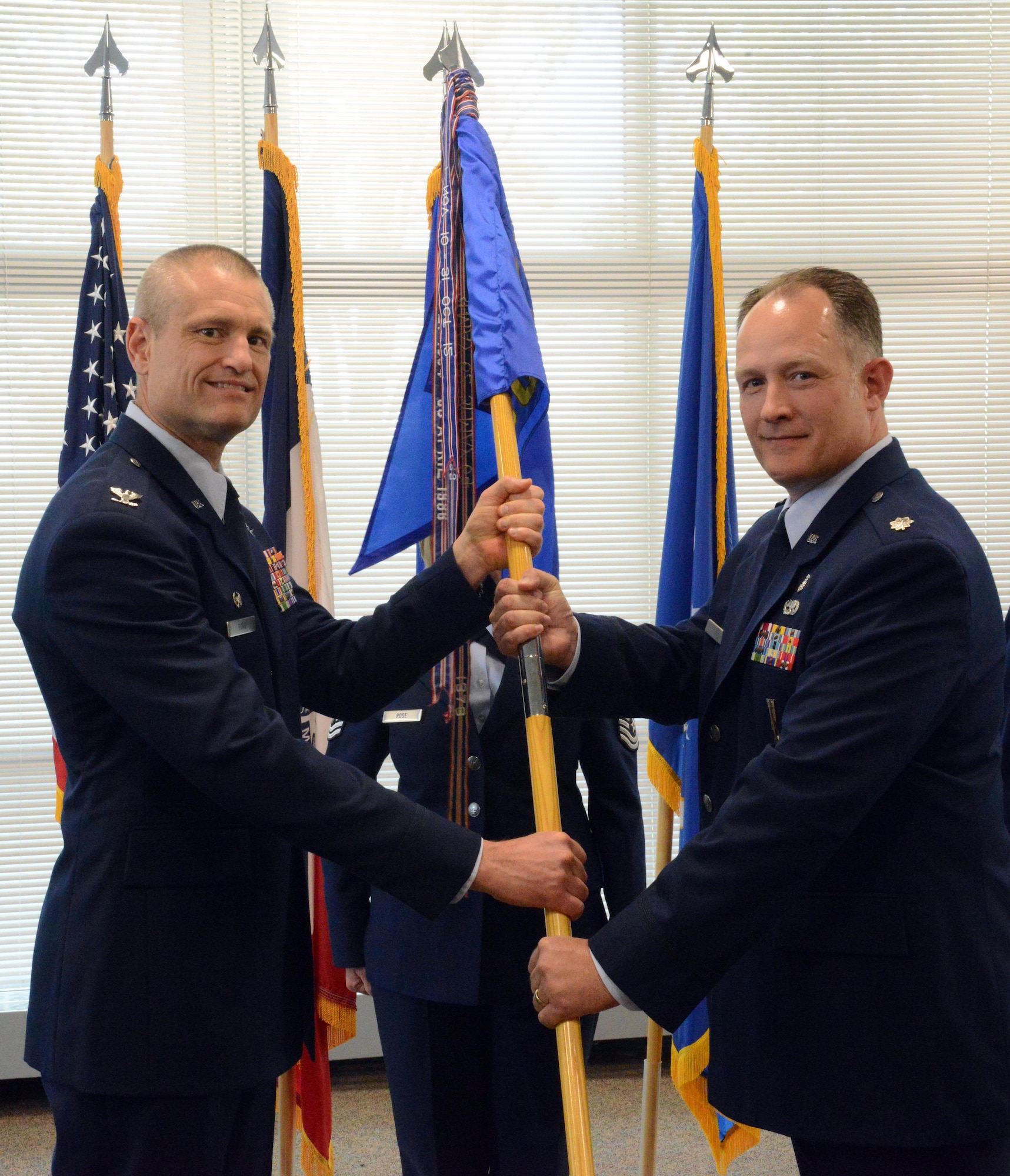 Lt. Col. Chad M. Hynnek (right), 132d Wing (132 WG) incoming Medical Group (MDG) commander and Col. Shawn D. Ford (left), commander 132 WG, pose for a photo during the exchange of the 132 WG MDG guidon during the change of command ceremony at the 132 WG MDG, Des Moines, Iowa on May 7, 2017. This action formally recognized Hynnek accepting the MDG commander role, Hynnek is the 10th commander of the MDG. (U.S. Air National Guard photo by Airman 1st Class Katelyn Sprott)