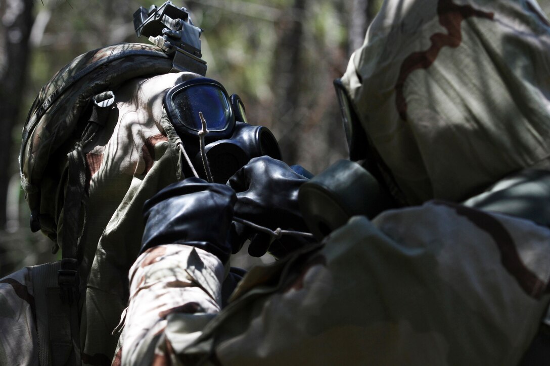 A 3rd Infantry Division cavalry scout at the Gainey Cup competition helps a teammate secure his protective gear during a chemical, biological, radiological and chemical lane at Fort Benning, Ga., May 2, 2017. Army photo by Staff Sgt. Candace Mundt