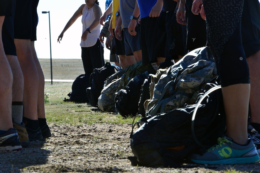 Ruck sacks sit at Team Cohesion Challenge participants’ feet just before the event at Schriever Air Force Base, Colorado, Friday, May 5, 2017. Participants carried the rucks about 10 miles during the event, all while completing team building challenges throughout the course. (U.S. Air Force photo/Brian Hagberg)