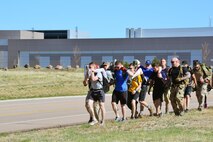 Team Cohesion Challenge participants carry “wounded” team members during the TCC at Schriever Air Force Base, Colorado, Friday, May 5, 2017. Participants navigated several scenarios during the 10-mile march, all designed to challenge them mentally and physically while teaching team-building skills. (U.S. Air Force photo/Brian Hagberg)