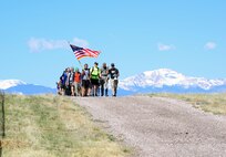 Participants crest a hill at Schriever Air Force Base, Colorado, during the Team Cohesion Challenge Friday, May 5, 2017. The TCC put participants through a series of challenges designed to test their mental and physical endurance and teach the importance of working together. (U.S. Air Force photo/Brian Hagberg)