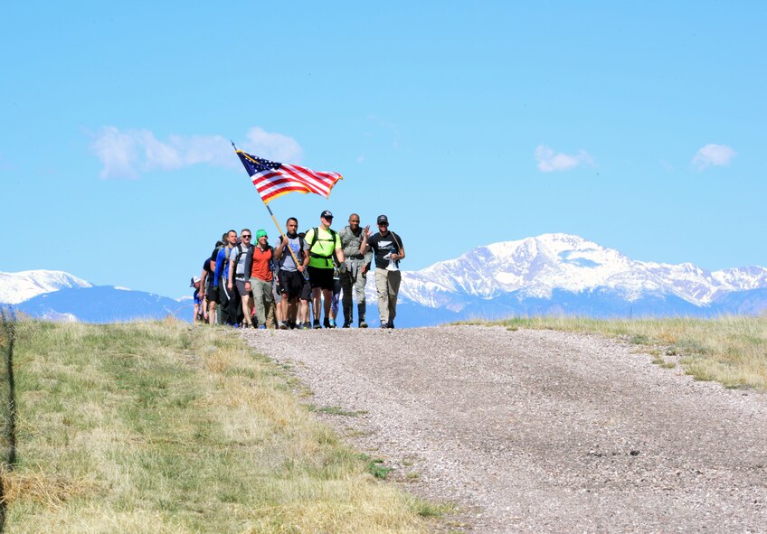 Participants crest a hill at Schriever Air Force Base, Colorado, during the Team Cohesion Challenge Friday, May 5, 2017. The TCC put participants through a series of challenges designed to test their mental and physical endurance and teach the importance of working together. (U.S. Air Force photo/Brian Hagberg)