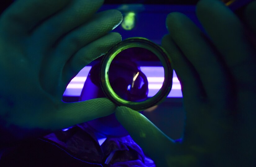U.S. Air Force Airman 1st Class Lacy Weeks, 1st Maintenance Squadron non-destructive inspection technician, inspects an aircraft part under black light at Joint Base Langley-Eustis, Va., May 4, 2017.  The part was dipped in a fluorescent penetrant to more easily detect surface faults such as dirt, cracks and erosion. (U.S. Air Force photo/Staff Sgt. Natasha Stannard)