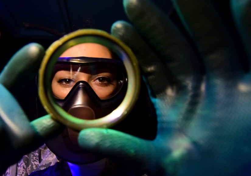 U.S. Air Force Airman 1st Class Lacy Weeks, 1st Maintenance Squadron non-destructive inspection technician, inspects an aircraft part under black light at Joint Base Langley-Eustis, Va., May 4, 2017. The technicians use tools including X-ray, magnetic, chemical and black light systems to check for destructive faults in parts and equipment. (U.S. Air Force photo/Staff Sgt. Natasha Stannard)