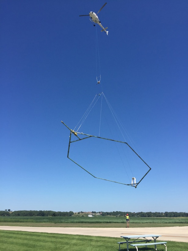 Scientific equipment is towed about 100 feet below the helicopter in a 'spider web' array to map geologic structures beneath the ground surface.