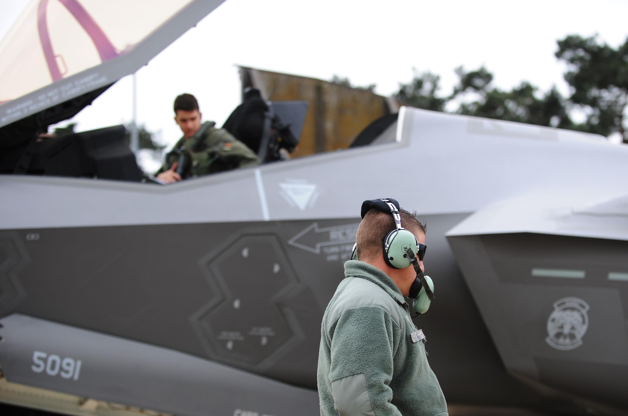 F-35A crew chief Brandon Bailey and F-35A pilot Stephen Nichols communicate before launching a training sortie from Royal Air Force Lakenheath, England. More than 200 Airmen from the active duty 388th and Reserve 419th Fighter Wings recently deployed overseas with 8 F-35As for the first time. (U.S. Air Force photo/Micah Garbarino) 