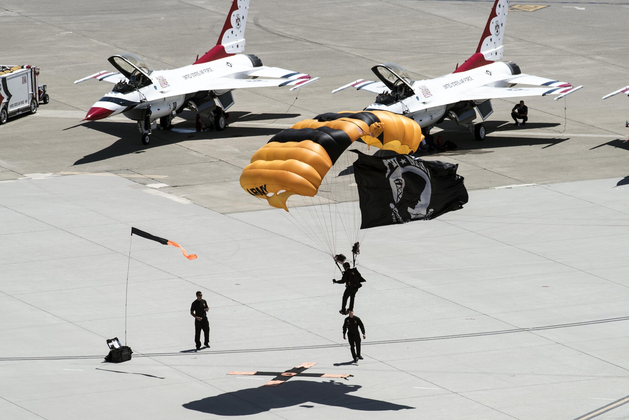 The U.S. Army Golden Knights descend upon Travis Air Force Base, Calif, May 7, 2017 with the Prisoner of War flag during the Wings Over Solano Air Show. The two-day event also featured performances by the U.S. Air Force Thunderbirds, flyovers and static displays. (U.S. Air Force photo by David Cushman)