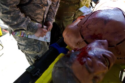 U.S. Army Reserve Soldiers assigned to the 409th Medical Company out of Madison, Wis., examine a casualty during Vibrant Response 17 at Camp Atterbury, Ind., May 7, 2017. The 409th Medical Company is assigned to Task Force 76 as one of their immediate medical care units. Vibrant Response 17 is an annual command post exercise that simulates the detonation of a nuclear bomb in a major city within the United States. This year it was integrated with Guardian Response 17 at Muscatatuck Urban Training Center, Indiana. The exercises enable emergency response organizations, both civilian and military, to integrate and provide relief during a catastrophic disaster. (U.S. Army Reserve Photo by Sgt. Stephanie Ramirez)