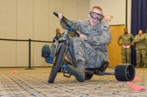 Airman 1st Class Logan Trowbridge, 436th Logistics Readiness Squadron, navigates his tricycle through an obstacle course while wearing “beer goggles” May 5, 2017, at The Landings on Dover Air Force Base, Del. Simulating driving under the influence, Trowbridge and other Team Dover members wore beer goggles at Dover’s Wingman University “You booze, you cruise, you lose” activity. (U.S. Air Force photo by Roland Balik)
