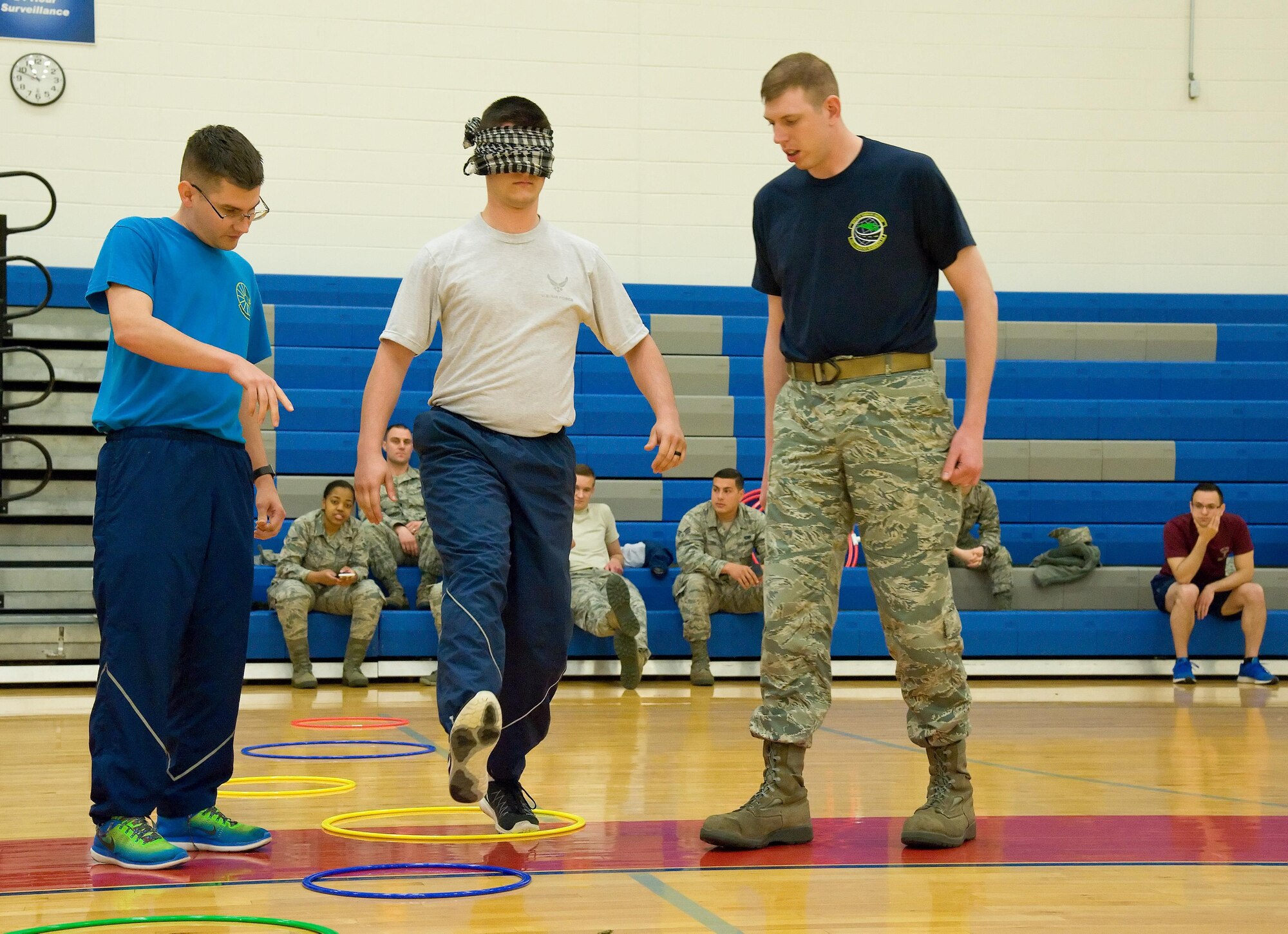 Tech. Sgt. Matthew Shaffer, 436th Force Support Squadron, left, and Staff Sgt. Benjamin Bisel, 436th Logistics Readiness Squadron, right, help guide Airman 1st Class Dylan Strickland, 436th Medical Operations Squadron, through an obstacle course while blind-folded May 5, 2017, at the Fitness Center on Dover Air Force Base, Del. Participating teams of three individuals from different squadrons relied on each other to complete numerous obstacles at Dover’s Wingman University “How did I get here” team building activity under the Comprehensive Airman Fitness “social” pillar. (U.S. Air Force photo by Roland Balik)
