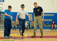 Tech. Sgt. Matthew Shaffer, 436th Force Support Squadron, left, and Staff Sgt. Benjamin Bisel, 436th Logistics Readiness Squadron, right, help guide Airman 1st Class Dylan Strickland, 436th Medical Operations Squadron, through an obstacle course while blind-folded May 5, 2017, at the Fitness Center on Dover Air Force Base, Del. Participating teams of three individuals from different squadrons relied on each other to complete numerous obstacles at Dover’s Wingman University “How did I get here” team building activity under the Comprehensive Airman Fitness “social” pillar. (U.S. Air Force photo by Roland Balik)