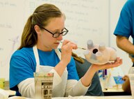 Staff Sgt. Abigail Paisley, 436th Force Support Squadron, puts the final touches of paint on her piggy bank May 5, 2017, at the Arts & Crafts Center on Dover Air Force Base, Del. Paisley was one of many Team Dover members that participated in the “Painting on Pottery” class, one of many classes offered during Dover AFB’s Wingman University. (U.S. Air Force photo by Roland Balik)
