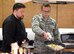 Robbie Jester, executive chef at the Stone Balloon Ale House, Newark, Del., instructs Senior Airman Brandon Crouch, 436th Aerial Port Squadron, how to flip a pan of chicken stir-fry May 5, 2017, at the Health Promotions Flight on Dover Air Force Base, Del. During Dover’s Wingman University “Dorm to Gourm” class, Jester instructed Crouch on the technique used to flip food in the pan for the first of two stir-fry dishes he made during the one-hour class. (U.S. Air Force photo by Roland Balik)