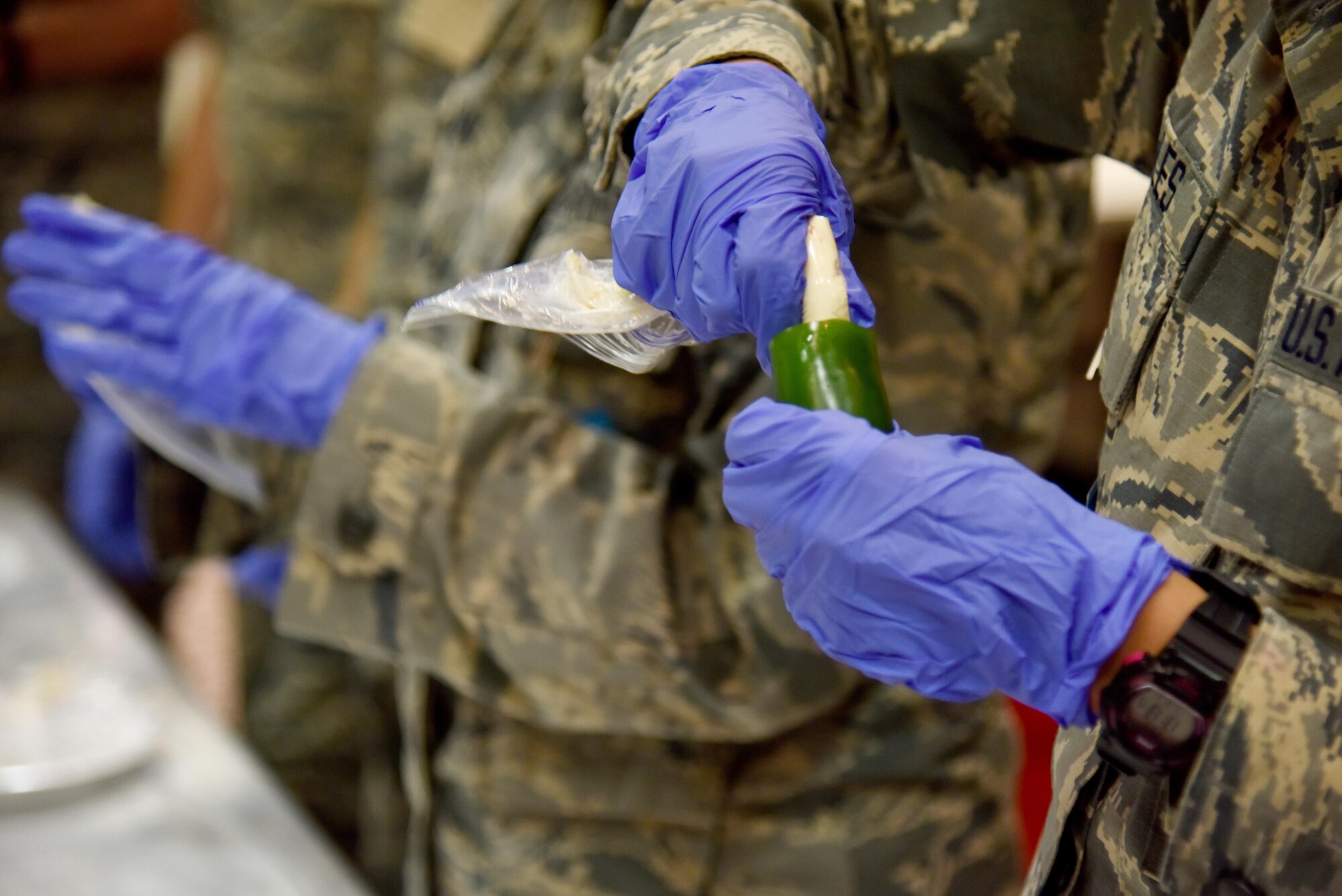 Airmen fill a jalapeno with a cream cheese mixture at the Top Tech competition in the Event Center on Goodfellow Air Force Base, Texas, May 5, 2017. During the competition, instructors had to teach a subject and audience members had to demonstrate their understanding of the topic. (U.S. Air Force photo by Staff Sgt. Joshua Edwards/Released)
