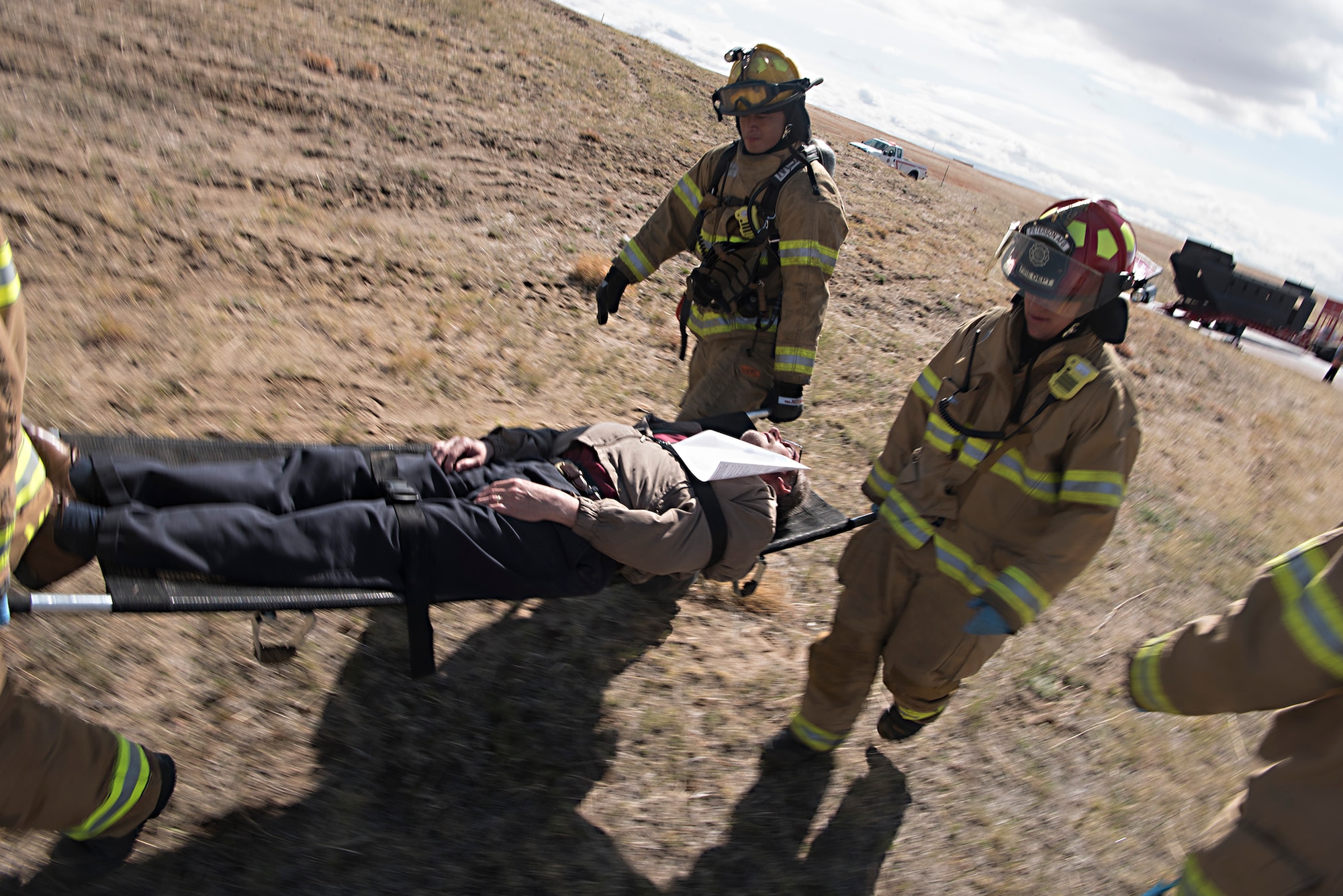 Firefighters from the Peterson Air Force Base Fire Department carry a simulated victim of a plane crash during the Freebird 2017 mass casualty exercise in Colorado Springs, Colo., May 5, 2017. The simulated victims have make-up applied to give the most realistic training available. (U.S. Air Force photo by Steve Kotecki)