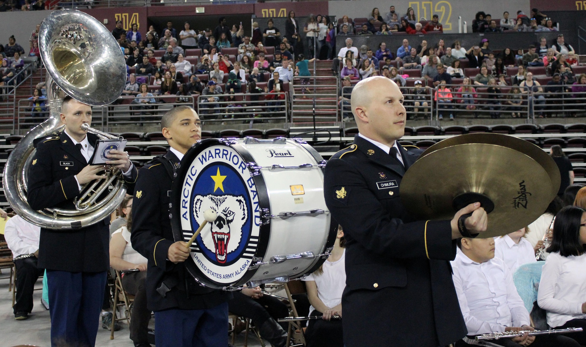 Spc. Paul Black, Spc. Victor Nichols and Spc. Scott Chmura with U.S. Army Alaska’s 9th Army Band stand ready to take direction from the conductor at Sonic Boom May 4 at the Sullivan Arena in Anchorage. More than 2,000 sixth-grade band and orchestra students from about 50 Anchorage School District schools participated in the event to showcase the district’s music programs and students.