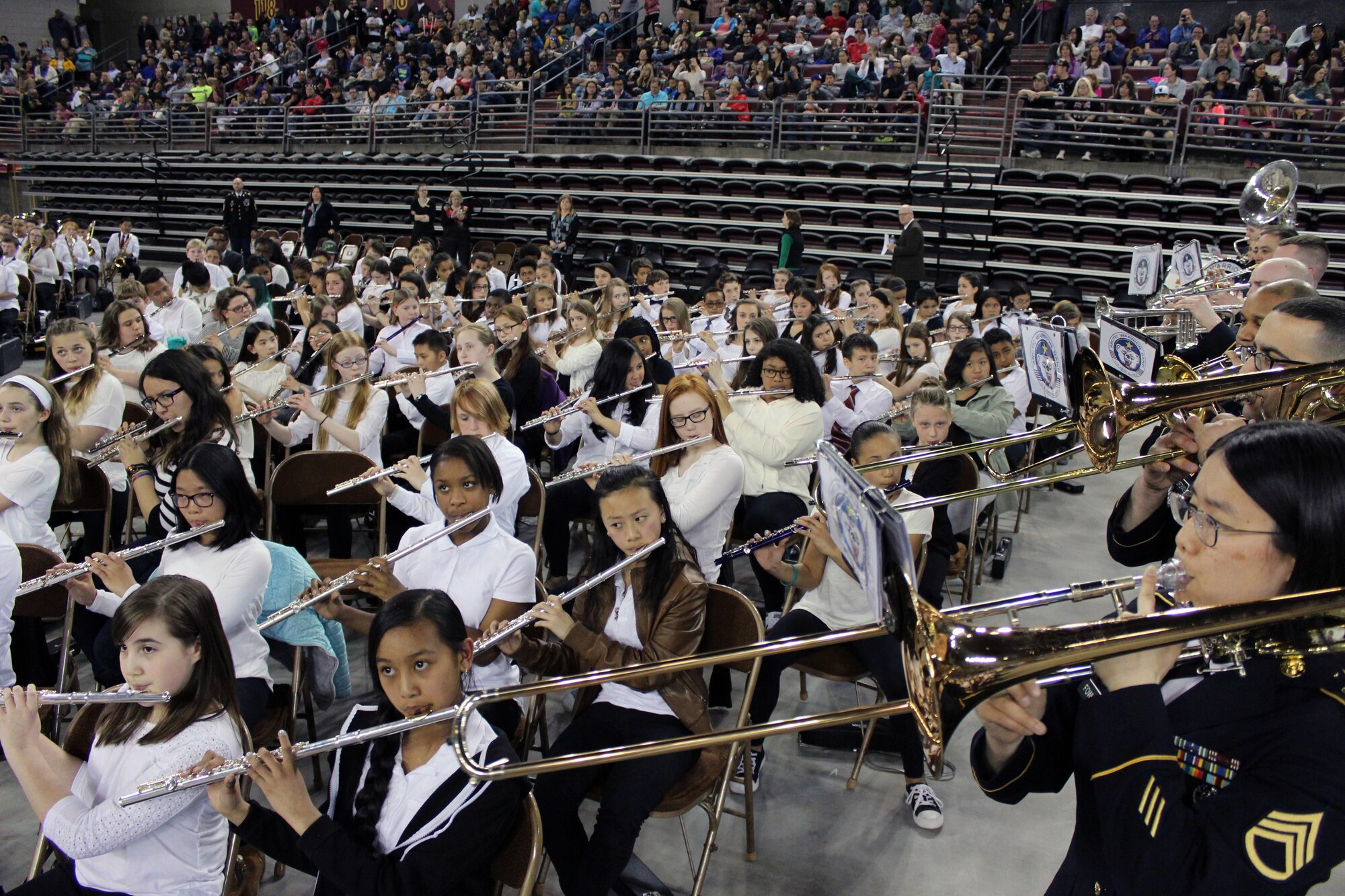 Members of U.S. Army Alaska’s 9th Army Band perform alongside the flute section at Sonic Boom May 4 at the Sullivan Arena in Anchorage. More than 2,000 sixth-grade band and orchestra students performed at the event, showcasing the skills they’ve learned during their first year of music education with the Anchorage School District.
