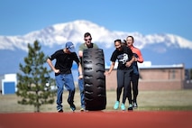 Amazing gRace participants, Elisha Patterson, Scott Balcao, Emily Schultz and Jordan Fobes, team name “The Misfits,” roll a tractor tire on the running track to complete one of their challenges at Schriever Air Force Base, Colorado, Thursday, May 4, 2017.  This team came together at the 11th hour to participate in the Amazing gRace, but finished strong despite being strangers. (U.S. Air Force photo/Dennis Rogers)