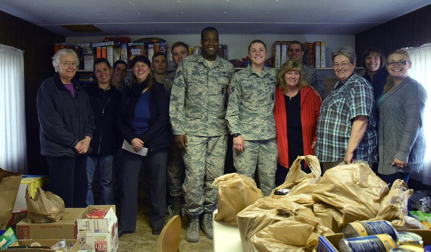 Schriever Airmen and donation workers from Ellicott Helping Hands Food Pantry gather with food collected for the Schriever Kids Helping Kids food drive in Ellicott, Colorado, Tuesday, May 9, 2017. Kids Helping Kids is a non-profit organization that helps children who are in need by sending food to their homes. (U.S. Air Force photo/Airman 1st Class William Tracy)